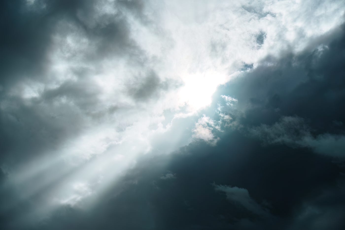 Sunlight breaks through dark storm clouds.